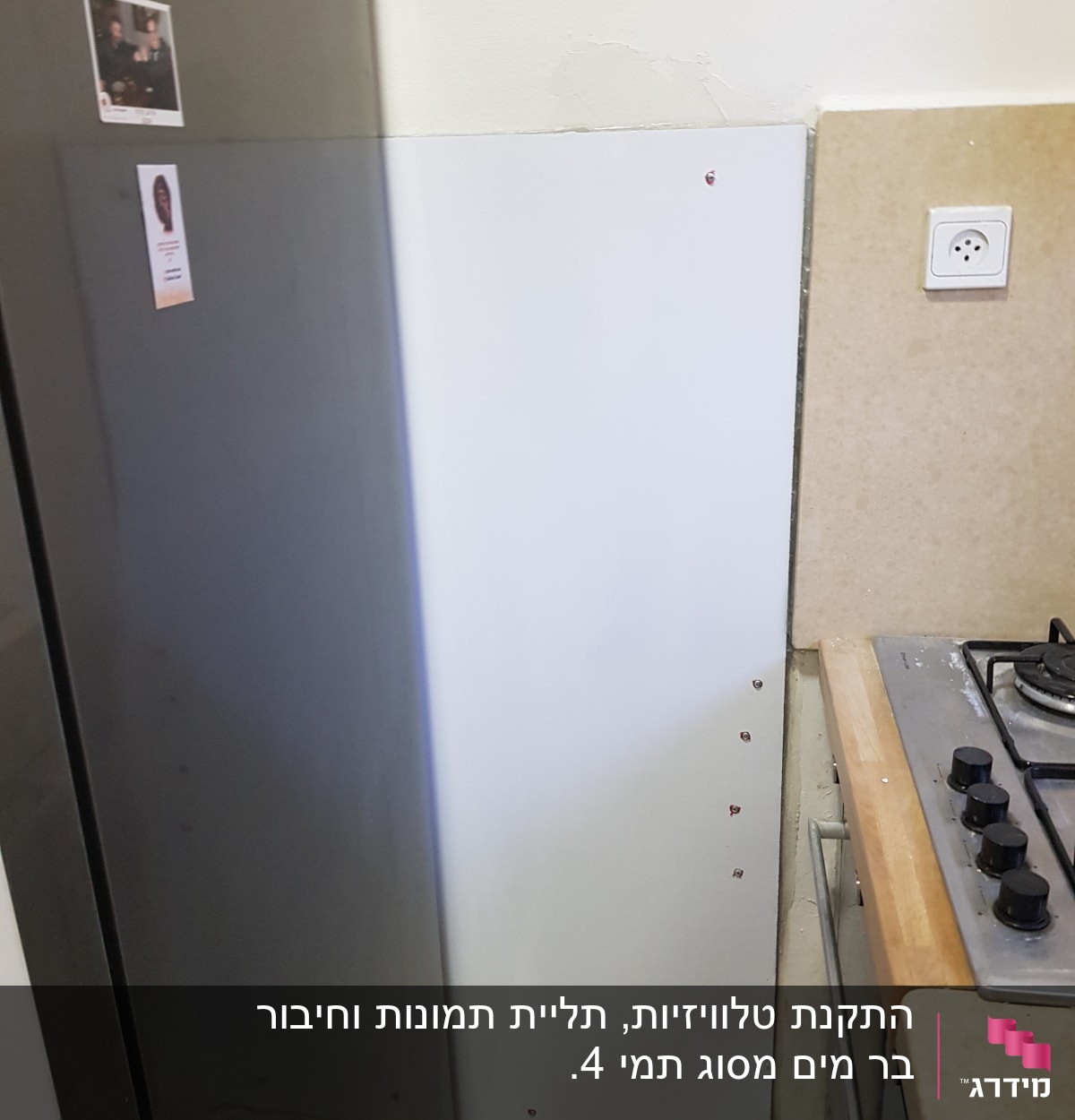 קיר עם לוח מתכת וברגים ליד כיריים